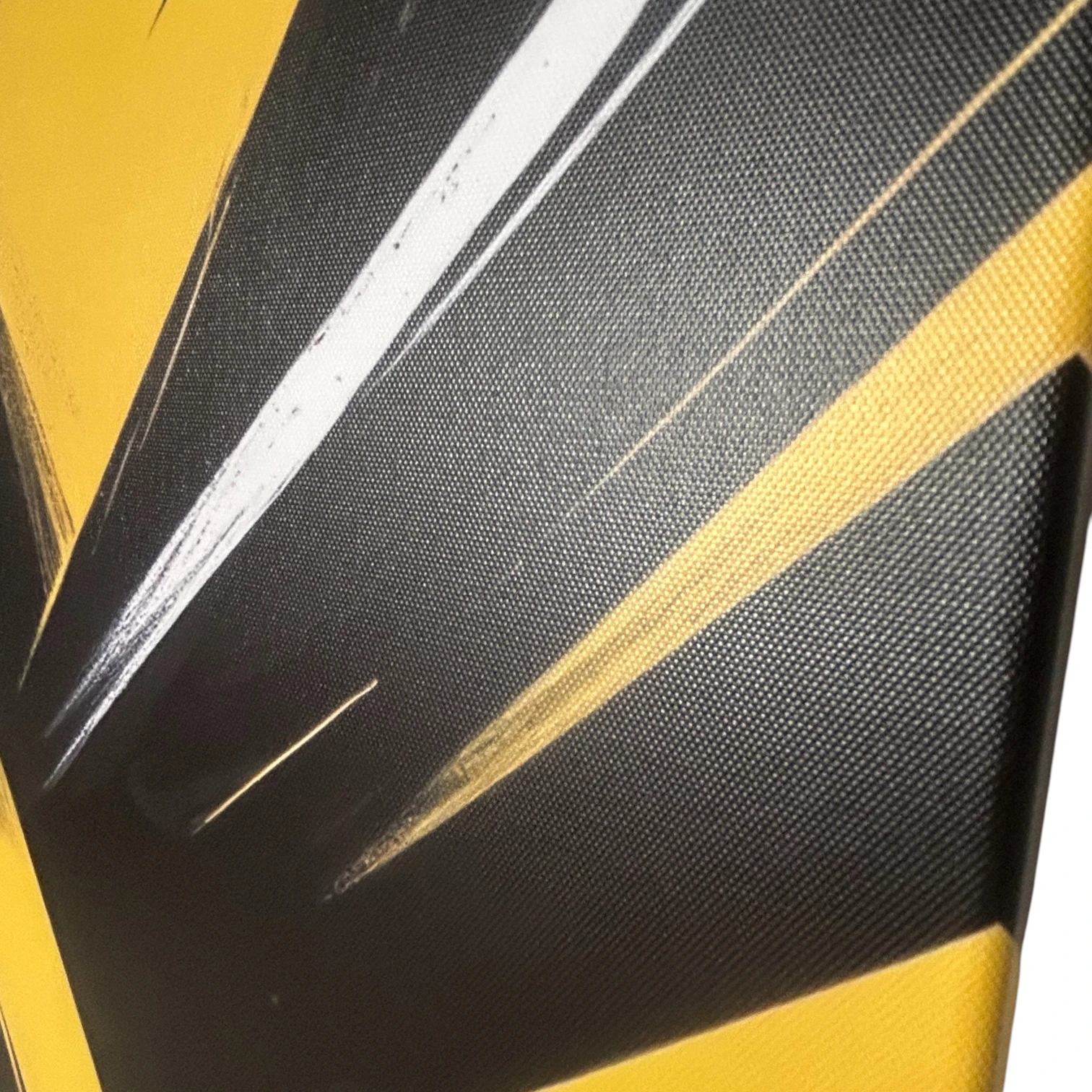 Gros-plan du tableau "Energie du Bitume" FLT montrant la texture de la toile et les détails des lignes jaunes et noires.