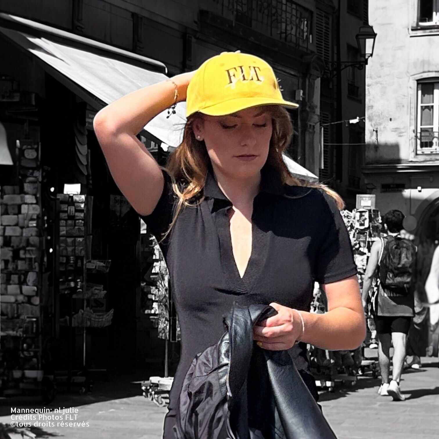 Femme portant la casquette FLT jaune dans un environnement urbain, style décontracté.