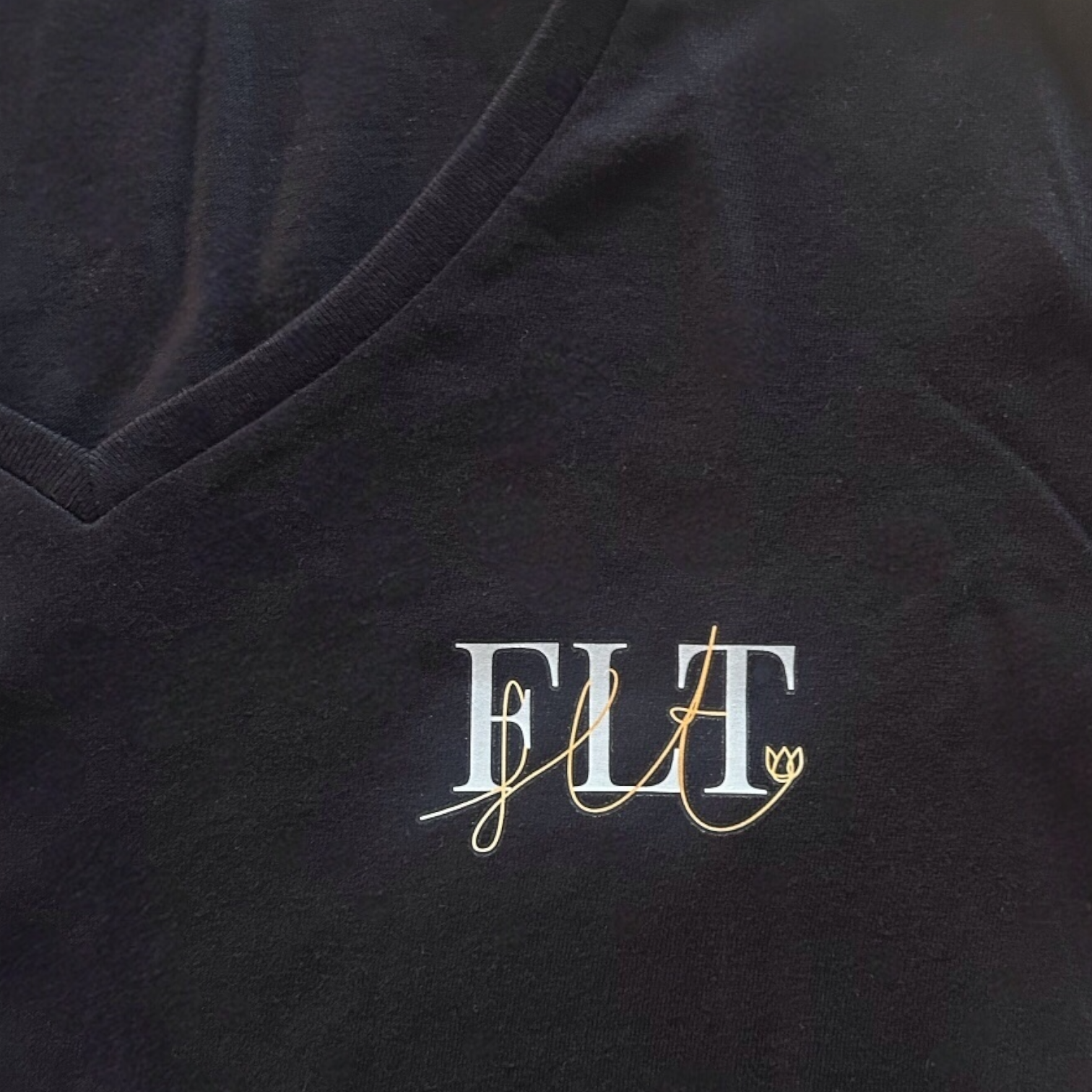 Détail du logo brodé sur le t-shirt femme col V